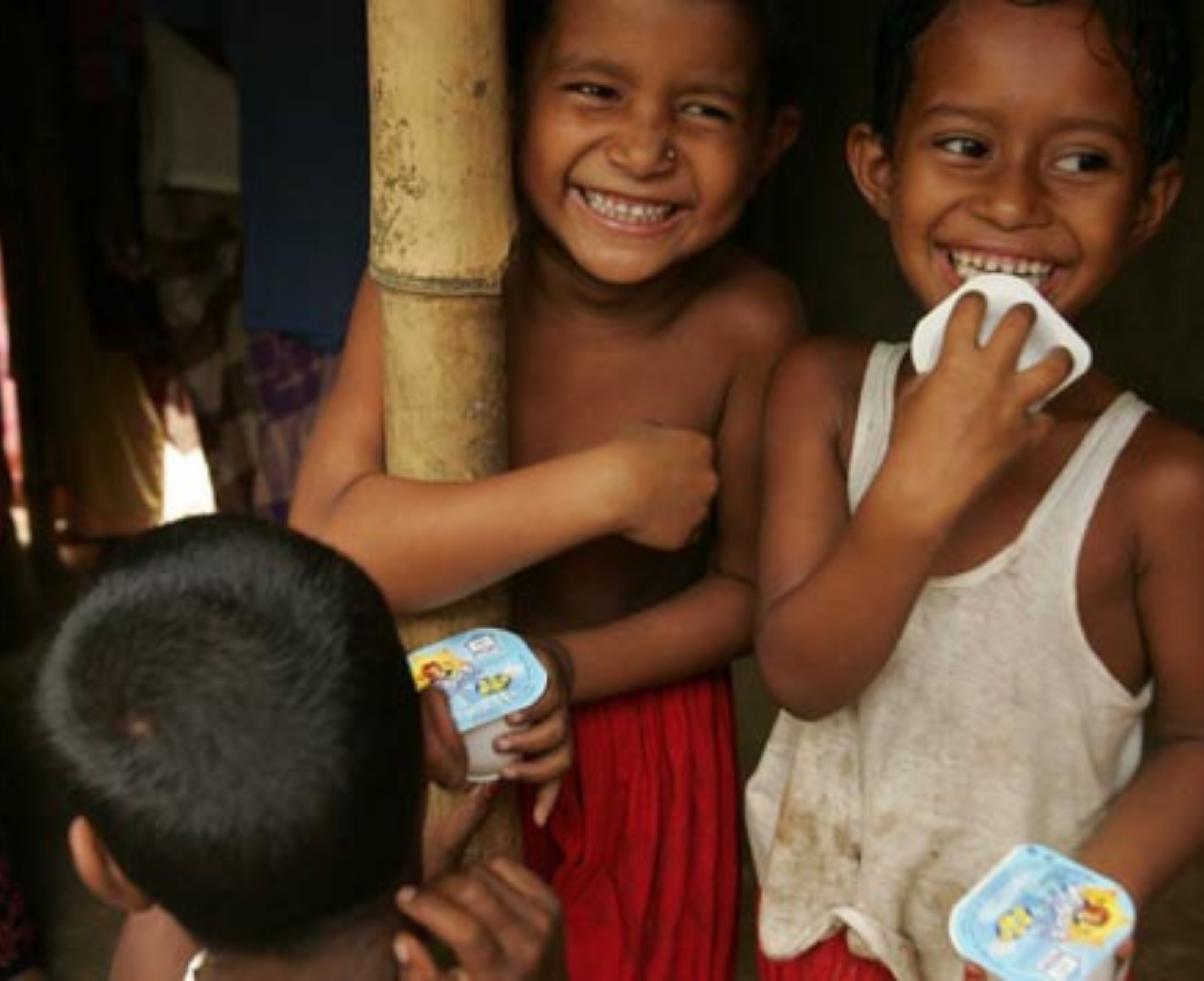 Des enfants souriant et mangeant un yaourt Des enfants souriant et mangeant un yaourt