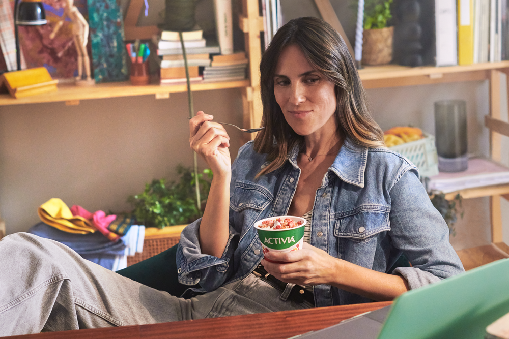 Working woman eating an Activia yoghurt