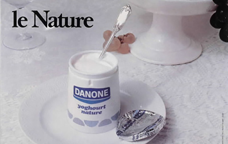 Yaourt nature Danone dans un pot en carton avec une cuillère Yaourt nature Danone dans un pot en carton avec une cuillère