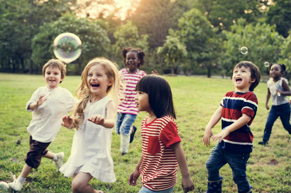 Enfants en train de jouer dehors avec des bulles de savon Enfants en train de jouer dehors avec des bulles de savon