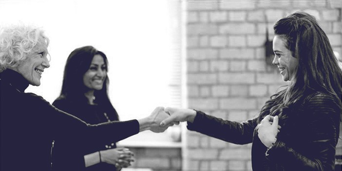 Des femmes souriantes se tiennent la main